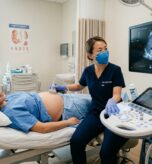 m_A_sonographer_performing_an_abdominal_ultrasound_o_da210afe69